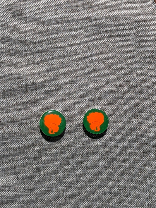 Green and Orange 1" diameter stud earring. Green background with orange an orange woman with mohawk hairstyle.