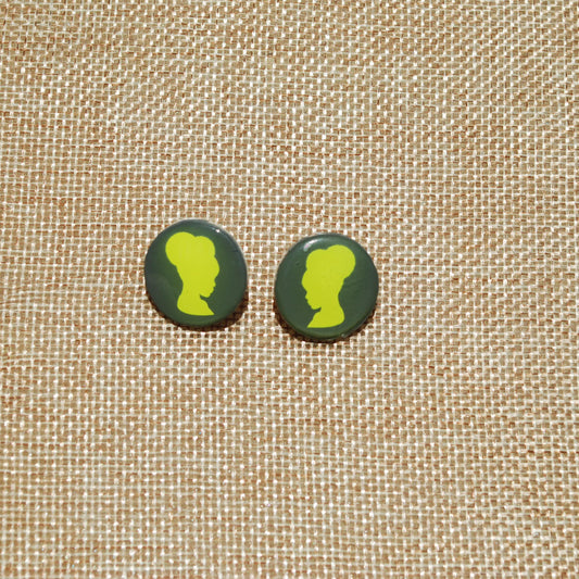 Gray and green 1" diameter round stud earring. Dark gray background with yellow girl with puffs applique.