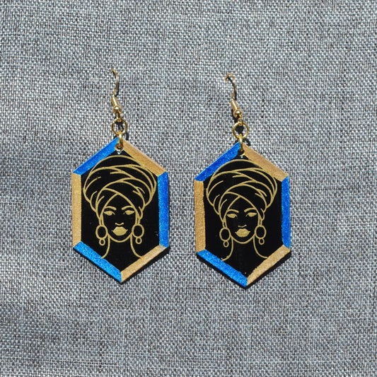 Black, blue, and gold hexagon earring. Black background with blue and gold trim. Gold outlined woman with head wrap applique.